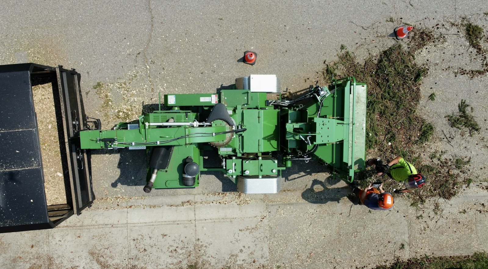 Limbs being fed into a wood chipper at the curb